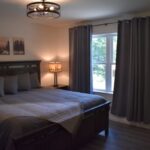 a bed with a lamp and a window